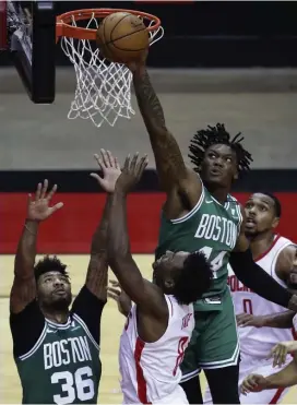  ?? AP Photos ?? NOT TODAY: Rob Williams blocks a shot from Houston’s Jae’Sean Tate (8) during the Celtics’ 134-107 rout on Sunday. Below, Tacko Fall throws down a dunk during the fourth quarter.