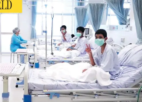  ?? THAI GOVERNMENT PUBLIC RELATIONS DEPARTMENT AND GOVERNMENT SPOKESMAN BUREAU / AFP / GETTY IMAGES ?? Members of the Wild Boars football team wave to the cameras in their hospital room in Chiang Rai, Thailand. The 12 boys rescued from a Thai cave were passed “sleeping” on stretchers through the passageway­s, a former Thai Navy SEAL said Wednesday, as...