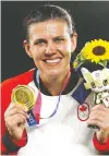  ?? NAOMI BAKER/GETTY IMAGES ?? Christine Sinclair shows off her gold medal for women's soccer in Yokohama on Saturday, local time.