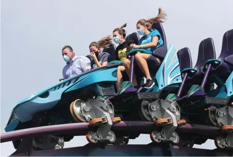  ?? tns file ?? THRILL SEEKERS: Masked visitors ride the Mako roller coaster on SeaWorld Orlando’s reopening day in June.