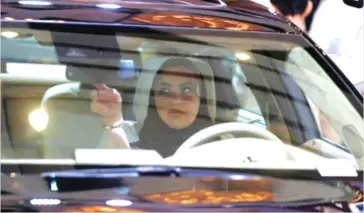  ??  ?? A Saudi woman fixes a mirror as she checks a car at a showroom in Riyadh. (Reuters)