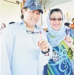  ??  ?? Mahmud and Hanifah show their inked fingers at SK Merpati Jepang.