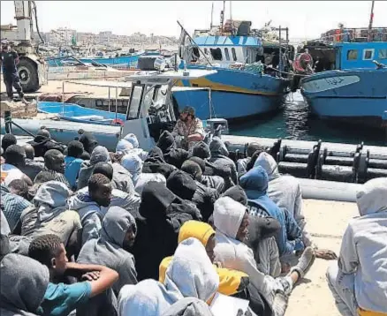  ?? MAHMUD TURKIA / AFP ?? Admirador de Gadafi. Mered, a la izquierda. Arriba, un grupo de emigrantes rescatados del mar, en el puerto de Trípoli