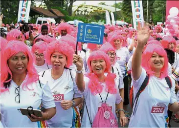  ?? — Bernama ?? Pretty in pink: Participan­ts waving as they start the Pink Wig-A-Thon walk at Perdana Botanical Garden.
