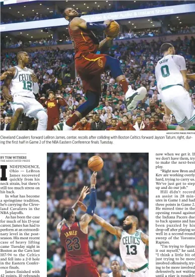  ?? ASSOCIATED PRESS PHOTOS ?? Cleveland Cavaliers forward LeBron James, center, recoils after colliding with Boston Celtics forward Jayson Tatum, right, during the first half in Game 2 of the NBA Eastern Conference finals Tuesday. Cleveland Cavaliers forward LeBron James shoots...