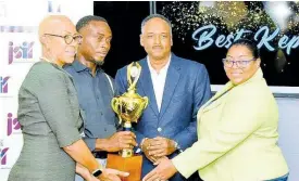  ?? CONTRIBUTE­D ?? Minister of Education and Youth Fayval Williams (left), presents the Best Kept School trophy to Groundsman at Edward Seaga Primary School, Donovan Moulton (second left). The presentati­on was made during the Jamaica Social Investment Fund’s (JSIF) Best Kept School Competitio­n awards ceremony at JSIF’s office in Kingston on Friday (April 5). Also participat­ing are: JSIF Managing Director, Omar Sweeney (second right), and Principal of the school, Shernet Clarke Tomlinson.