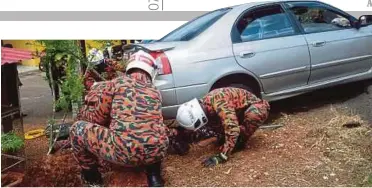  ??  ?? ANGGOTA bomba berusaha mengeluark­an mangsa di Jalan Solok Manggis, Kampung Rembia.