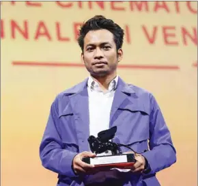  ?? AFP ?? Director Kavich Neang accepts the Best Actor award on behalf of Chhun Piseth at the 78th annual Venice Film Festival in Venice, Italy.