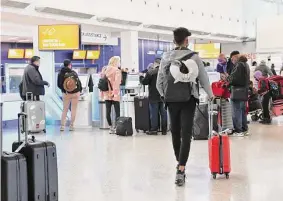  ?? Michael M. Santiago/Getty Images ?? People check in for their flights at New York’s JFK Airport on Jan. 11, shortly after an FAA technology breakdown that was addressed at Tuesday’s hearing.