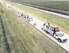  ?? REBECCA BLACKWELL AP ?? In this photo taken with a drone, farmworker­s and allies march through agricultur­al land on the first day of a five-day trek to highlight the Fair Food Program, which has enlisted food retailers to use their clout with growers to ensure better working conditions and pay.