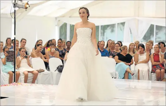  ?? Picture: ALAN EASON ?? ELEGANT SWIRL: Leigh Gouws models a wedding gown from the House of Deonalee at a fashion show, part of the annual bridal fair at the East London Golf Club on Saturday