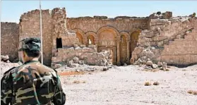  ?? GEORGE OURFALIAN/GETTY-AFP ?? A Syrian government soldier patrols Sunday at an archaeolog­ical site. In the southweste­rn part of the country, shooting stopped ahead of a cease-fire deadline, residents said.