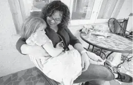  ?? JAY REEVES/AP ?? Sarah Clemente snuggles with a daughter, Penelope, on Saturday at their home. Clemente, of Charleston, West Virginia, supported a proposal for paid family medical leave.