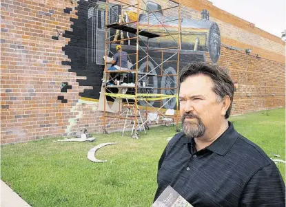  ?? R. Clayton McKee / For the Chronicle ?? Rosenberg Main Street manager Dan Kelleher has ambitious plans for downtown events and improvemen­ts. The city’s council recently budgeted funds for the effort. Behind Kelleher, muralist Paul Sanchez works on a train coming out of a wall.