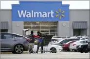  ?? MATT ROURKE — THE ASSOCIATED PRESS FILE ?? A Walmart employee helps a customer outside the store in Philadelph­ia. Walmart reported stronger sales for the fiscal first quarter, but its profits took a beating as the nation’s largest retailer grappled with surging inflation on food and fuel and higher costs from a still snarled global supply chain.