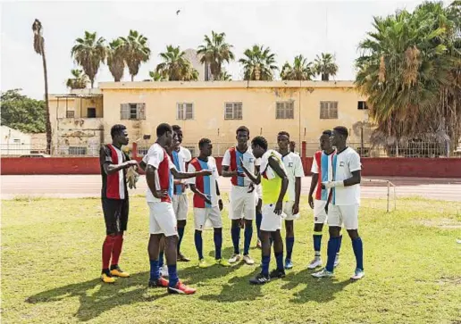  ??  ?? I calciatori della Spes discutono nell'intervallo di una partita della Spes Cup 2018, disputata in giugno. Sullo sfondo, la periferia di Dakar.