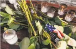  ??  ?? The memorial, including candles and flowers, was erected Thursday evening by a group calling itself Bay Area Alt Right.