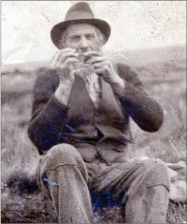  ??  ?? Denis Daniel Guiney, pictured lighting his pipe while working in the Bog at his home in Knocknenau­gh, Ballydesmo­nd, (circa 1940s).
Denis Daniel is the subject of Seán Keating’s painting ‘The Fenian’.