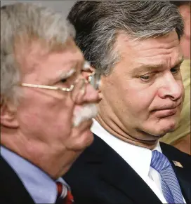  ?? MARK WILSON / GETTY IMAGES ?? National security adviser John Bolton (left) and FBI Director Christophe­r Wray listen during the news conference Thursday at the White House.