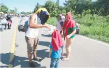  ??  ?? Bajo los intensos rayos del sol, una familia de migrantes caminó 35 kilómetros hasta Tapachula, pese a la amenazas de ser detenidos.