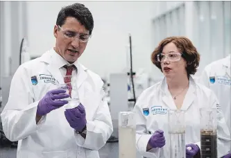  ?? JASON FRANSON THE CANADIAN PRESS ?? Prime Minister Justin Trudeau and Dr. Heather Kaminsky test clay, water and bitumen from a tailings pond for recycling during a visit to the Northern Alberta Institute of Technology's Productivi­ty and Innovation Centre.