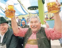  ??  ?? With beer flowing by the litre at Oktoberfes­t, Bavarians are happy to share a toast with friendly foreigners.