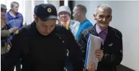  ?? (Igor Podgorny/Reuters) ?? HISTORIAN YURI DMITRIEV is escorted by a police officer upon his arrival for a court hearing in Petrozavod­sk, Russia, last year.