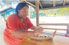  ?? ?? Saluoy Hantalae, 62, is a Lipe island Urak Lawoi villager. Here she shows a traditiona­l sea gypsy ‘ga-bang’ model boat.