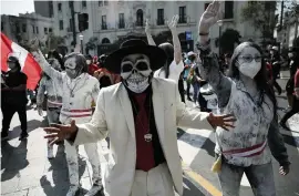  ?? RODRIGO ABD AP ?? Protesters dressed in zombie-like costumes to represent Peru’s newly sworn-in president and his ministers, wave as they arrive in Lima’s Plaza San Martin where people who are refusing to recognize the new government gathered Saturday.