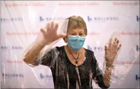  ?? (AP Photo/Emilio Morenatti) ?? Isabel Pérez López, 96, embraces her daughter, Beatriz Segura, 67, through a plastic screen June 22 at Ballesol Puig i Fabra nursing home in Barcelona, Spain. At the height of Spain’s coronaviru­s outbreak, nursing homes locked out visitors to try to shield their residents from the virus.