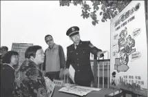  ?? ZHU JIPENG / FOR CHINA DAILY ?? A police officer promotes telecom fraud awareness among residents in Wuxi, Jiangsu province, in April.