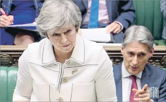  ?? HO / AFP ?? La primera ministra británica, Theresa May, ayer ante los Comunes, junto al ministro de Economía, Philip Hammond