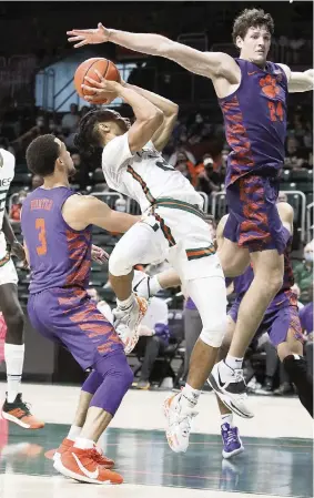  ?? ANDREW ULOZA FOR THE MIAMI HERALD ?? UM’s Isaiah Wong attempts a shot surrounded by Clemson defenders Saturday in the Canes’ ACC opener at Watsco Center in Coral Gables.