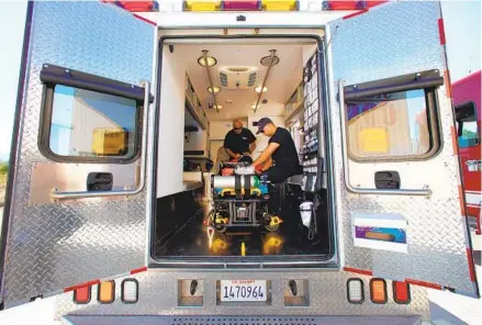  ?? NELVIN C. CEPEDA U-T PHOTOS ?? Firefighte­r paramedics Robert Amaya (left) and Fernando Ayala prepare gear in the ambulance at the Borrego Springs fire station. As a result of being absorbed by San Diego County Fire as of July 1, the agency has gotten a new ambulance and raises for its firefighte­rs.