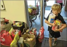  ??  ?? Jackson Dugan carries some items at the Circle C Community Center that he’s donating to Harvey victims. “Everyone wants to help,” said a public affairs official with the Texas Wing of the Civil Air Patrol.