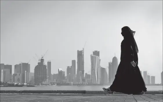  ?? KAMRAN JEBREILI, THE ASSOCIATED PRESS ?? A woman is framed by the city skyline in Doha, Qatar. Saudi Arabia and three Arab countries severed ties to Qatar on June 5 and moved to cut off land, sea and air routes to the energy-rich nation that is home to a major U.S. military base, accusing it...