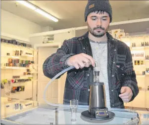  ?? CHRIS SHANNON/CAPE BRETON POST ?? Coastal Vapor employee Dylan Muise explains how the sophistica­ted Arizer Extreme-Q vaporizer works at the shop he manages on Charlotte Street in Sydney. The owner of Coastal Vapor, Walter Burgess, says he’s preparing to stock up on merchandis­e and...