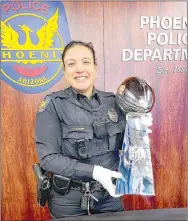  ?? Submitted photo ?? Phoenix police officer Christina Chavez, shown holding the Super Bowl 57 championsh­ip trophy as part of the NFL’s policy allowing police personnel from host cities to take photos with the trophy. Chavez scored 16 points and made two clutch free throws to provide the winning margin when her hometown of Hardin defeated Fergus County, 56-54, in the 1994 Montana Class A state championsh­ip game at Columbia Falls.