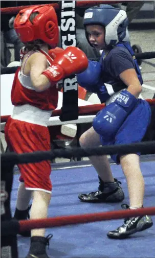  ??  ?? Above: Swift Current's Jaden Toye (at right) hits Weyburn's Elias Weston with a straight left punch during their bout in the 54-kg weight class. Lloyminste­r's Sydney Collinge (at left) and Swift Current's Dashanda Fehr-Spence size each other up during their bout.