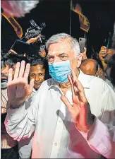  ?? AGENCIES ?? PM Ranil Wickremesi­nghe visits a Buddhist temple on Thursday and (left) people protest against shortage of fuel and cooking gas by blocking a road, in Colombo.