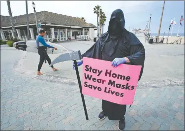  ?? (File photo/AP/Chris Carlson) ?? Spencer Kelly, dressed as the grim reaper, demonstrat­es in May in favor of the stay-at-home order during the coronaviru­s pandemic at the pier in Huntington Beach, Calif. The Los Angeles County Department of Public Health is ordering county beaches closed through July 6.