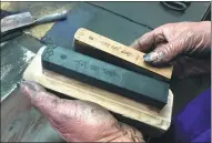  ?? CHENG SI / CHINA DAILY ?? Wang Yunqian, a craftsman at Wang Aijun’s workshop, takes a finished inkstick out of a mold.
