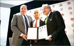  ?? SPENCER PLATT/GETTY IMAGES/AFP ?? US football chief Sunil Gulati (centre) and his Canadian and Mexican counterpar­ts Victor Montaglian­i (left) and Decio De Maria hold up a signed joint bid for the 2026 World Cup in New York City on Monday.