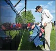  ?? MACOMB DAILY FILE PHOTO ?? Patrick Degens, 76, kneels as he finds the name of a past comrade on the Traveling Vietnam Wall That Heals in Clinton Township. Harold Beard, a volunteer from Mount Clemens, helped him find the name.