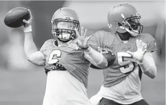  ?? Ron Schwane / Associated Press ?? The Cleveland Browns are in no rush to make rookie Baker Mayfield, left, their starting quarterbac­k over Tyrod Taylor, right, despite Mayfield’s showing in his first preseason game.