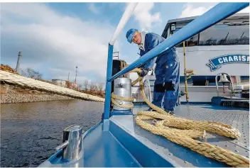  ?? FOTO: MARKUS SCHOLZ/DPA ?? Julian Schnieders befestigt an Bord des Tankschiff­s „Charisma“eine sogenannte Festmacher­leine.