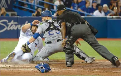  ?? The Canadian Press ?? Toronto Blue Jay Kendrys Morales, left, is tagged out at home plate by Texas Rangers’ catcher Jonathan Lucroy during eighth inningAmer­icanLeague­baseballac­tiononFrid­ayinToront­o.TheJayswon­7-6.