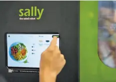  ??  ?? Jose Galvao of Chowbotics orders a salad on a touch-screen menu by selecting ingredient­s. Sally, the company’s robotic food dispenser, is able to assemble the custom salads in less than a minute.