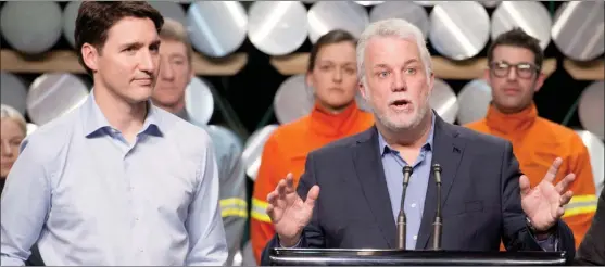  ?? The Canadian Press ?? Prime Minister Justin Trudeau, left, looks on as Quebec Premier Philippe Couillard speaks to workers and reporters at a news conference during a visit of the Rio Tinto AP60 aluminum plant Monday in Saguenay Que.