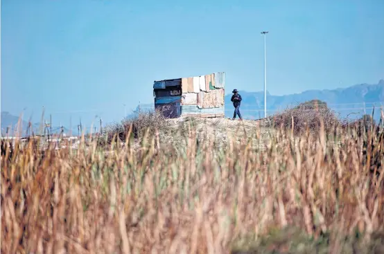  ?? AFP ?? Scene of an illegally establishe­d settlement in Khayelitsh­a, 35km from the centre of Cape Town, on May 17. Roughly 200 people have taken over a plot of land here and erected ramshackle shelters. Such illegal land seizures have surged in recent months,...